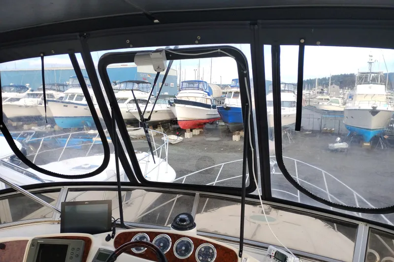 Slide: The Image of 2004 Meridian 459 Motoryacht cockpit view with marina and boats in background. - 16