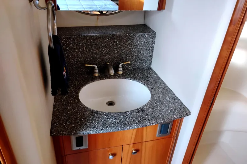 Slide: The Image of 2004 Meridian 459 Motoryacht bathroom sink with granite countertop and wooden cabinetry. - 43