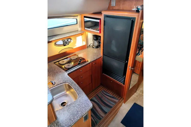Slide: The Image of 2004 Meridian 459 Motoryacht kitchen with stove, sink, and refrigerator. - 47
