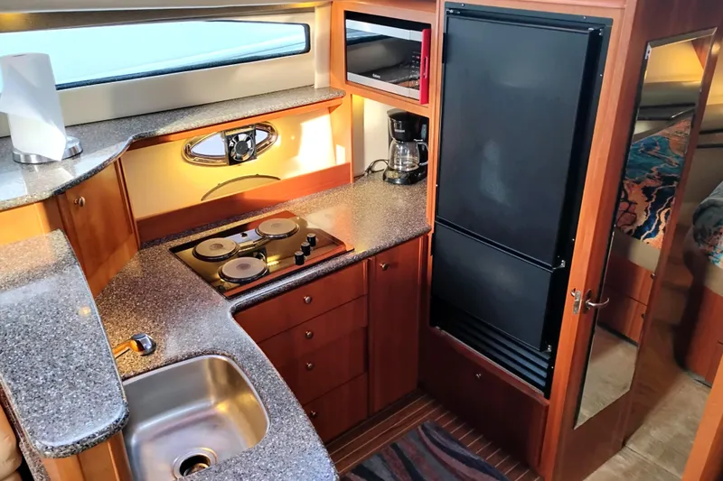 Slide: The Image of 2004 Meridian 459 Motoryacht kitchen with stove, sink, and refrigerator. - 48
