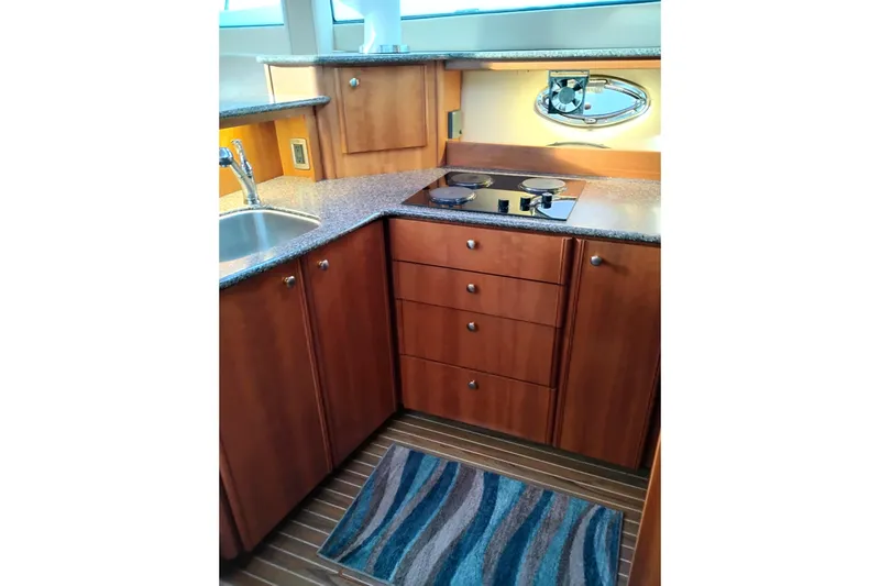 Slide: The Image of 2004 Meridian 459 Motoryacht kitchen with wooden cabinets, stove, and sink. - 50
