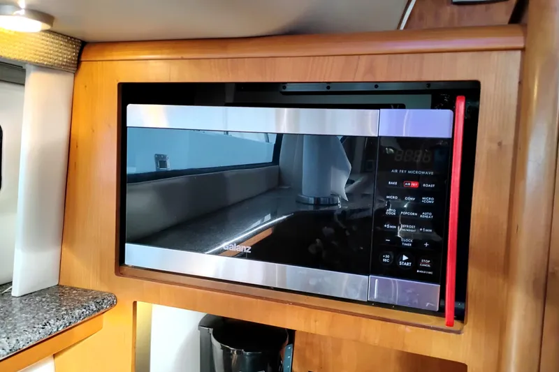 Slide: The Image of Microwave in 2004 Meridian 459 Motoryacht kitchen, featuring wood cabinetry and modern design. - 53