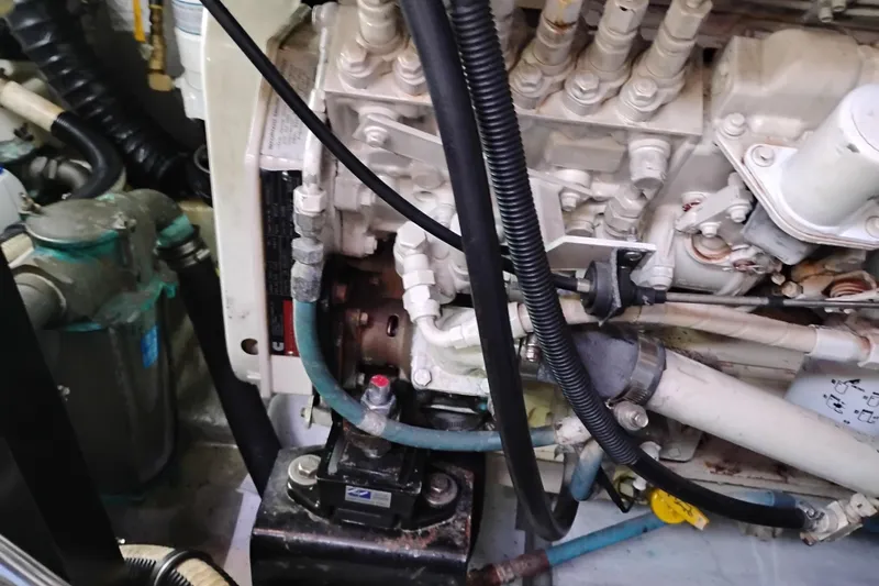 Slide: The Image of Engine compartment of a 2004 Meridian 459 Motoryacht, showcasing mechanical components and hoses. - 76