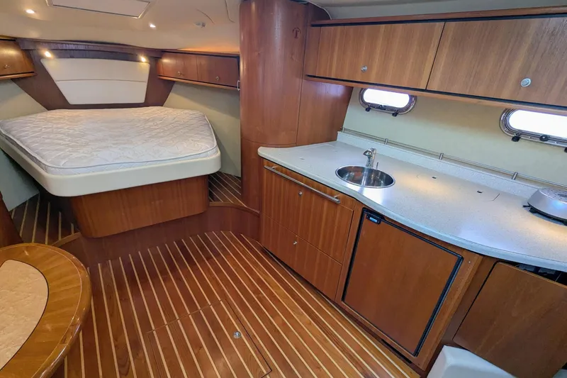Slide: The Image of 2008 Tiara Yachts 3600 Sovran interior with bed, kitchenette, and wood finish. - 32