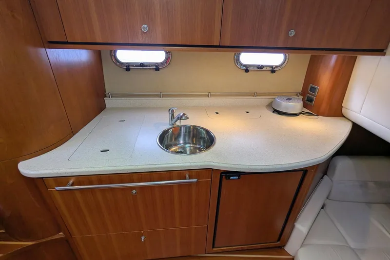 Slide: The Image of 2008 Tiara Yachts 3600 Sovran galley with wood cabinetry and modern sink. - 34