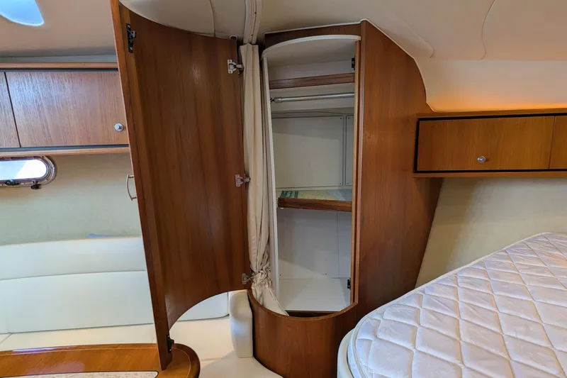 Slide: The Image of 2008 Tiara Yachts 3600 Sovran interior with open wooden cabinet and bed. - 37