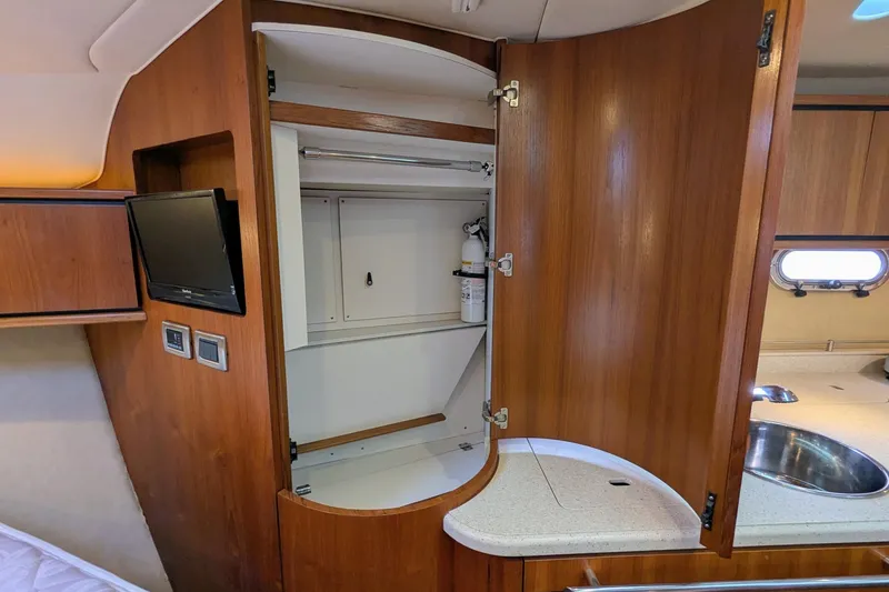 Slide: The Image of 2008 Tiara Yachts 3600 Sovran interior with open wooden cabinet and small TV. - 38