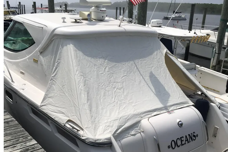 Slide: The Image of 2008 Tiara Yachts 3600 Sovran docked, covered with a white tarp, American flag displayed. - 47