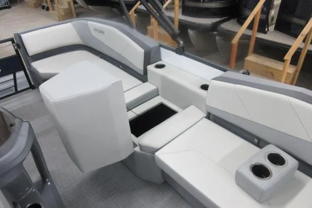 Slide: The Image of 2026 Sylvan A-16 boat interior with gray and white seating, cup holders, and storage compartments. - 11
