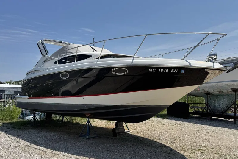 Slide: The Image of 2004 Regal 3060 Window Express boat on stands, black and white hull, outdoor setting. - 1