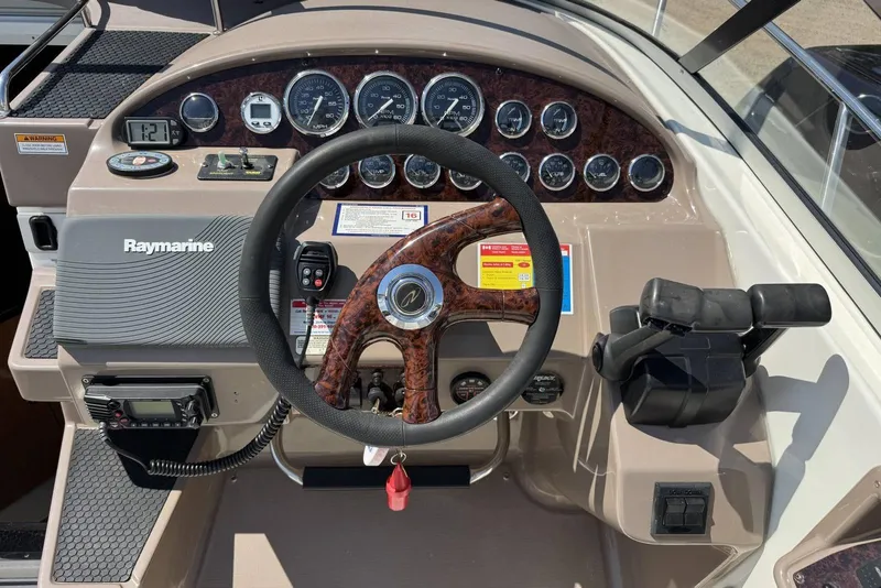 Slide: The Image of 2004 Regal 3060 Window Express boat dashboard with steering wheel and Raymarine equipment. - 10