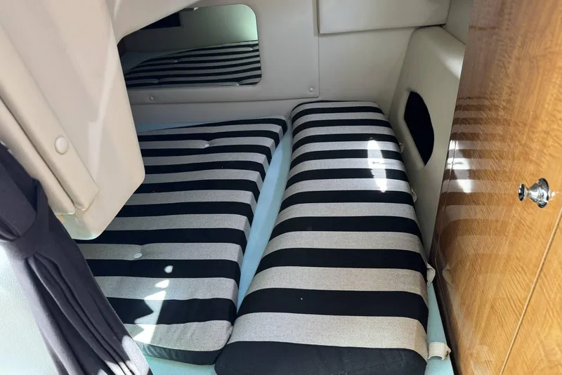 Slide: The Image of 2004 Regal 3060 Window Express cabin with striped cushions and wooden cabinetry. - 13