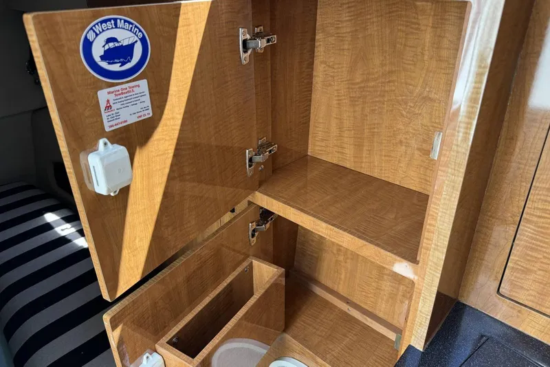 Slide: The Image of Open wooden cabinet inside a 2004 Regal 3060 Window Express boat. - 14