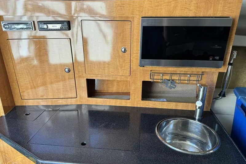 Slide: The Image of 2004 Regal 3060 Window Express boat interior with kitchenette, sink, and storage cabinets. - 15