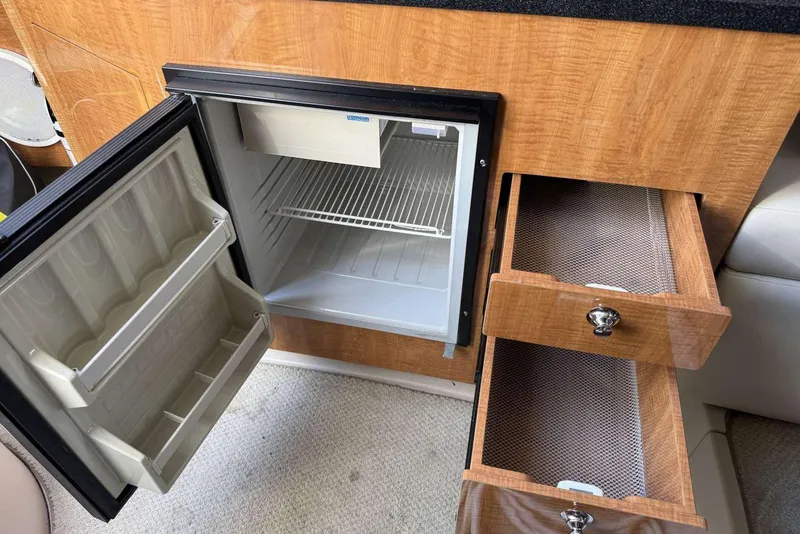 Slide: The Image of 2004 Regal 3060 Window Express interior with open fridge and wooden drawers. - 16