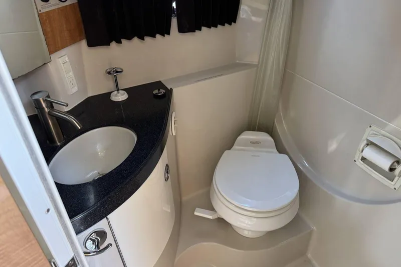 Slide: The Image of 2004 Regal 3060 Window Express bathroom with sink, toilet, and black countertop. - 19