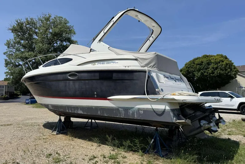 Slide: The Image of 2004 Regal 3060 Window Express boat on stands, parked outdoors on a sunny day. - 4