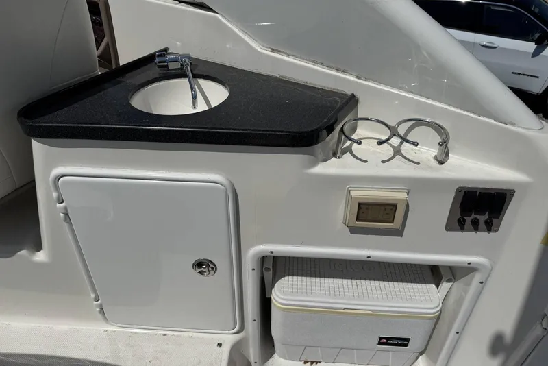 Slide: The Image of 2004 Regal 3060 Window Express boat interior with sink, storage, and control panel. - 8