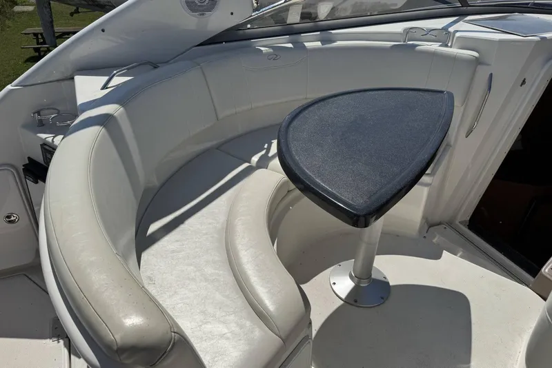 Slide: The Image of 2004 Regal 3060 Window Express boat interior with curved seating and table. - 9