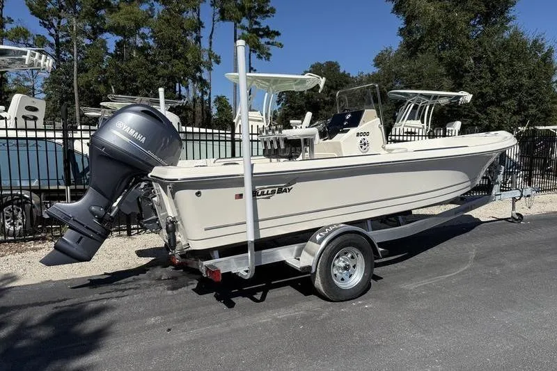 Slide: The Image of 2026 Bulls Bay 2000 boat on trailer with Yamaha outboard motor, parked outdoors. - 2