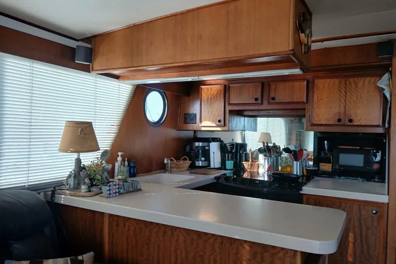 Slide: The Image of Interior of 1977 Hatteras 48 Long Range Cruiser with wooden cabinetry and kitchen amenities. - 11