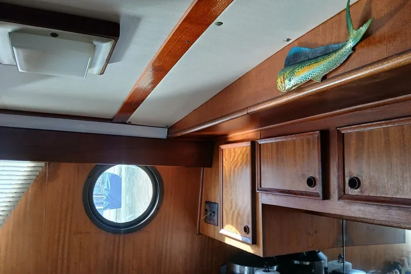 Slide: The Image of Interior of 1977 Hatteras 48 Long Range Cruiser with wood cabinets and fish decor. - 12