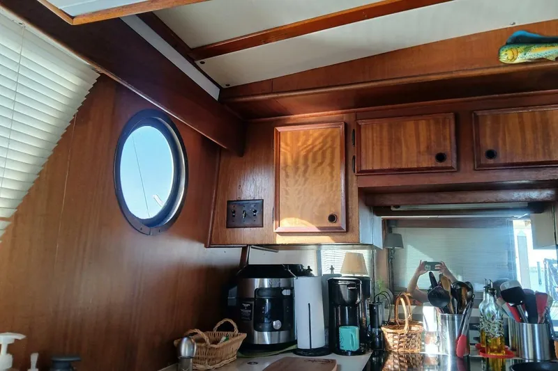 Slide: The Image of Interior of 1977 Hatteras 48 Long Range Cruiser with wooden cabinets and kitchen appliances. - 13