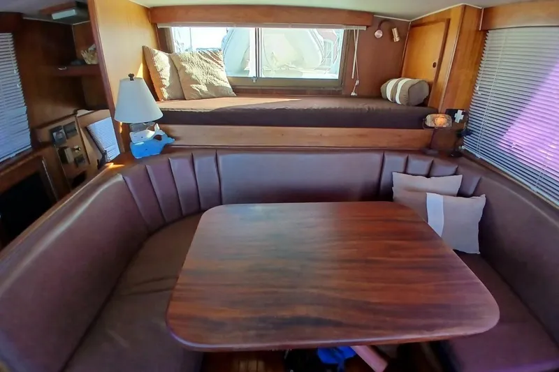 Slide: The Image of Interior of 1977 Hatteras 48 Long Range Cruiser with cozy seating and wooden table. - 22