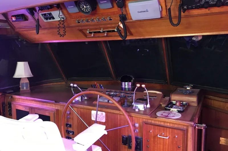 Slide: The Image of 1977 Hatteras 48 Long Range Cruiser helm with wooden wheel and navigation equipment. - 25