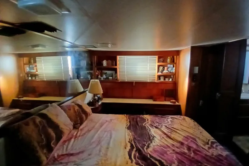 Slide: The Image of Cozy bedroom interior of 1977 Hatteras 48 Long Range Cruiser with wood paneling and soft lighting. - 29
