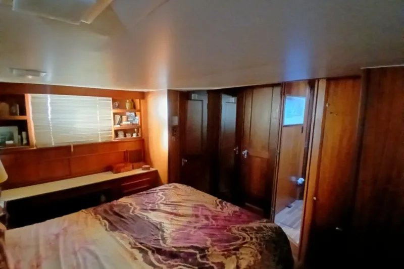 Slide: The Image of 1977 Hatteras 48 Long Range Cruiser bedroom with wood paneling and cozy decor. - 30