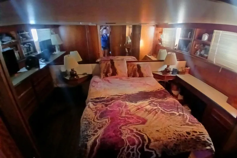 Slide: The Image of Cozy bedroom interior of 1977 Hatteras 48 Long Range Cruiser with vibrant bedding. - 31