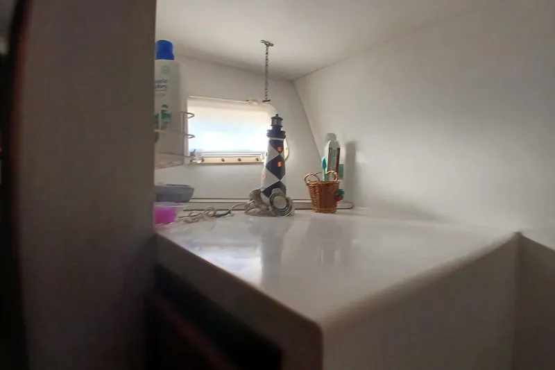 Slide: The Image of 1977 Hatteras 48 Long Range Cruiser interior with toiletries and window view. - 38