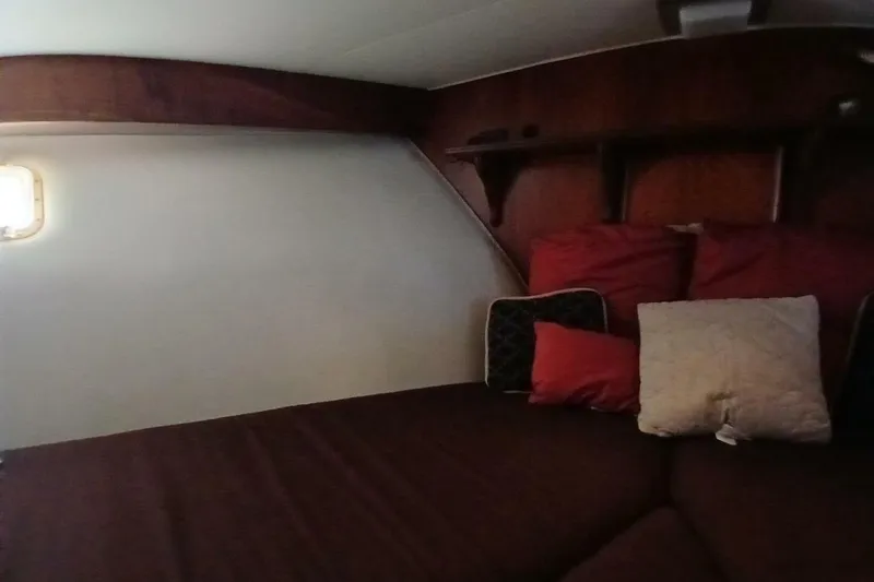 Slide: The Image of Cozy cabin interior of 1977 Hatteras 48 Long Range Cruiser with cushions and wooden shelves. - 44