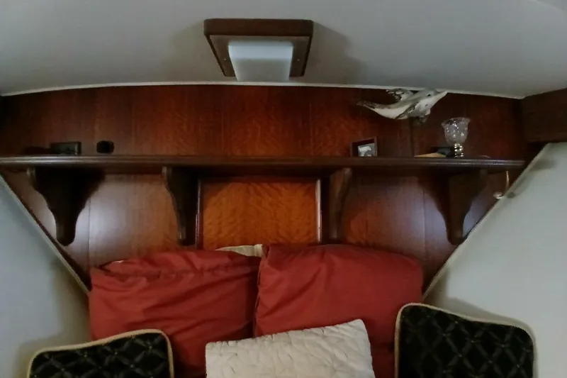 Slide: The Image of Interior of 1977 Hatteras 48 Long Range Cruiser with wooden shelves and red cushions. - 45