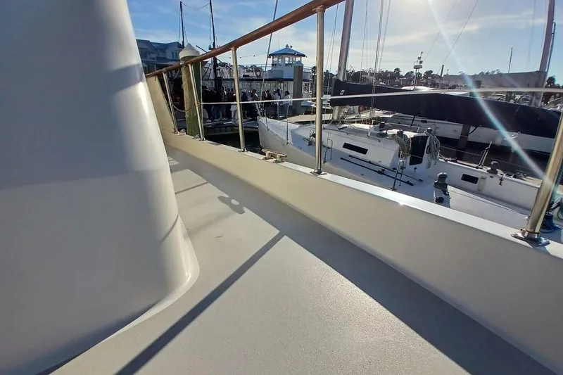 Slide: The Image of 1977 Hatteras 48 Long Range Cruiser deck view at marina with sailboats. - 49