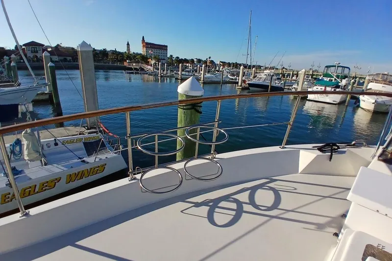 Slide: The Image of 1977 Hatteras 48 Long Range Cruiser docked in a scenic marina. - 50