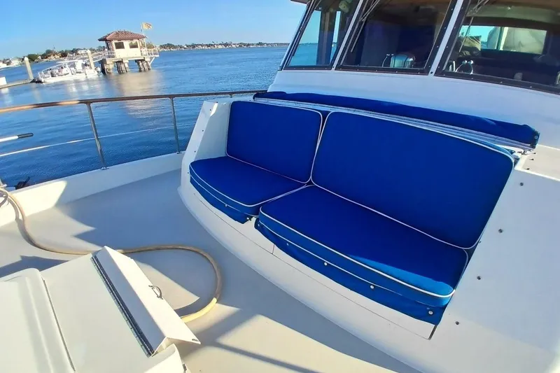 Slide: The Image of 1977 Hatteras 48 Long Range Cruiser with blue cushioned seating on deck. - 53