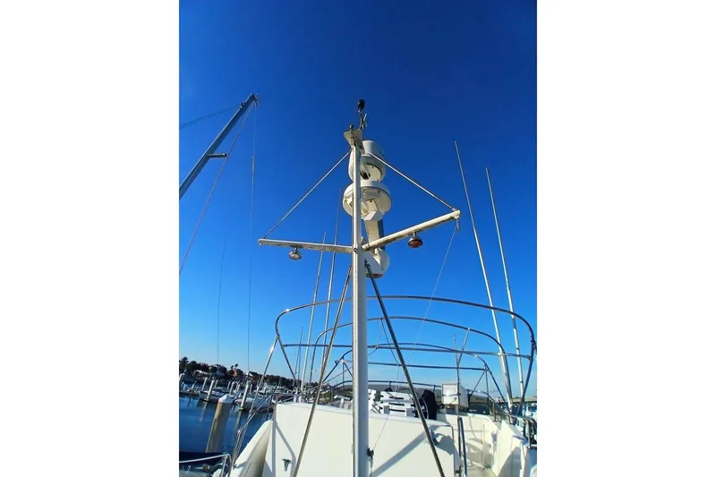 Slide: The Image of 1977 Hatteras 48 Long Range Cruiser mast against clear blue sky at marina. - 55