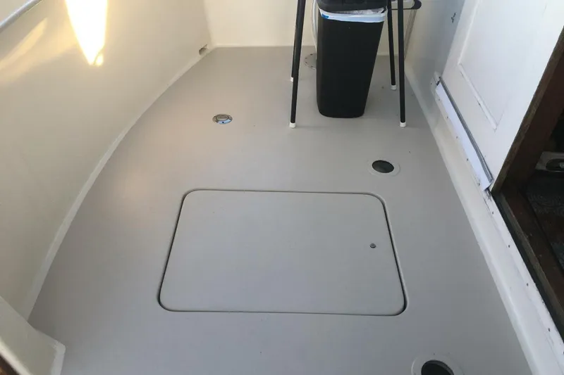 Slide: The Image of 1977 Hatteras 48 Long Range Cruiser deck with storage hatch and trash bin. - 57