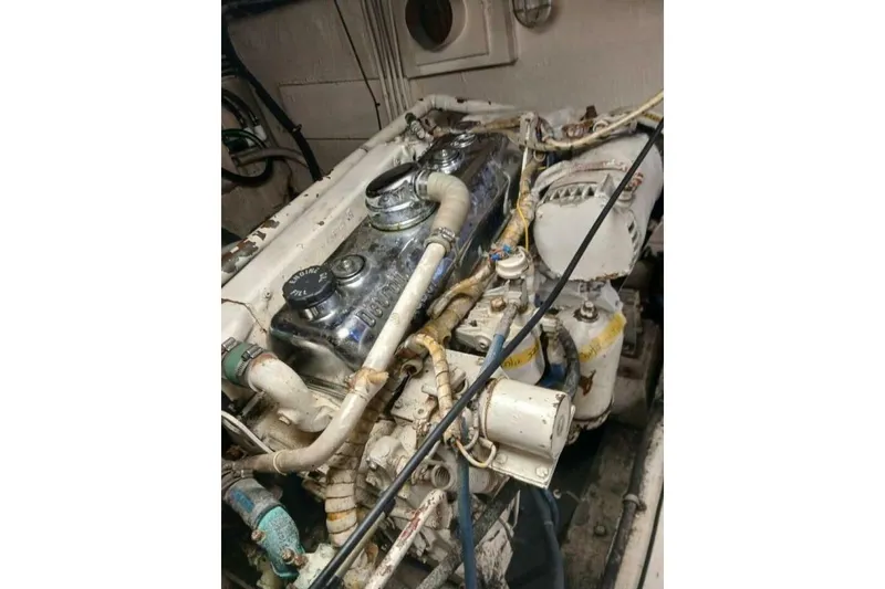 Slide: The Image of Engine room of 1977 Hatteras 48 Long Range Cruiser, showcasing mechanical components. - 61