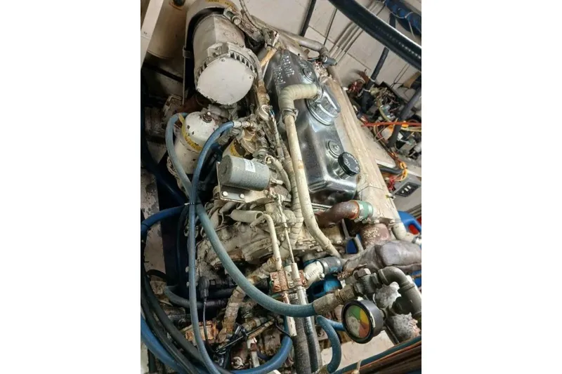Slide: The Image of Engine of a 1977 Hatteras 48 Long Range Cruiser with visible hoses and components. - 62
