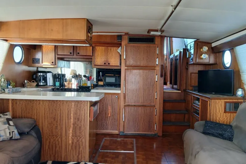 Slide: The Image of Interior of 1977 Hatteras 48 Long Range Cruiser with wood cabinetry and modern amenities. - 7