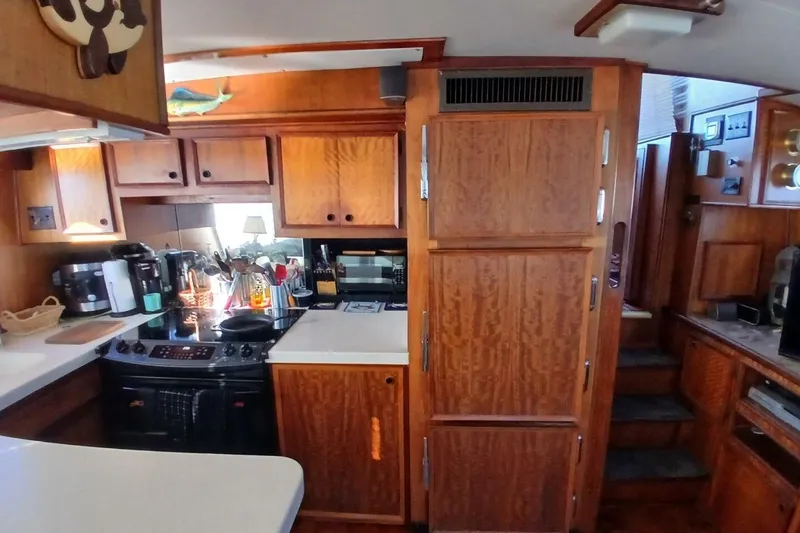 Slide: The Image of 1977 Hatteras 48 Long Range Cruiser kitchen with wooden cabinetry and modern appliances. - 9