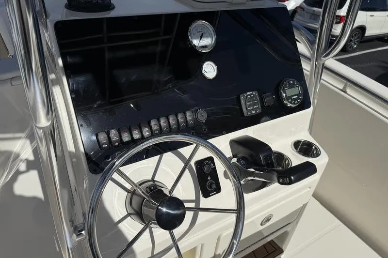 Slide: The Image of 2025 Bulls Bay 230 Center Console boat dashboard with steering wheel and controls. - 11