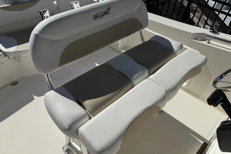 Slide: The Image of 2025 Bulls Bay 230 Center Console boat seating area with cushioned bench. - 13