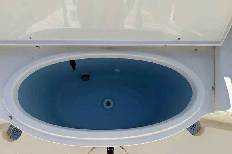 Slide: The Image of Livewell on 2025 Bulls Bay 230 Center Console boat, featuring oval design and blue interior. - 19