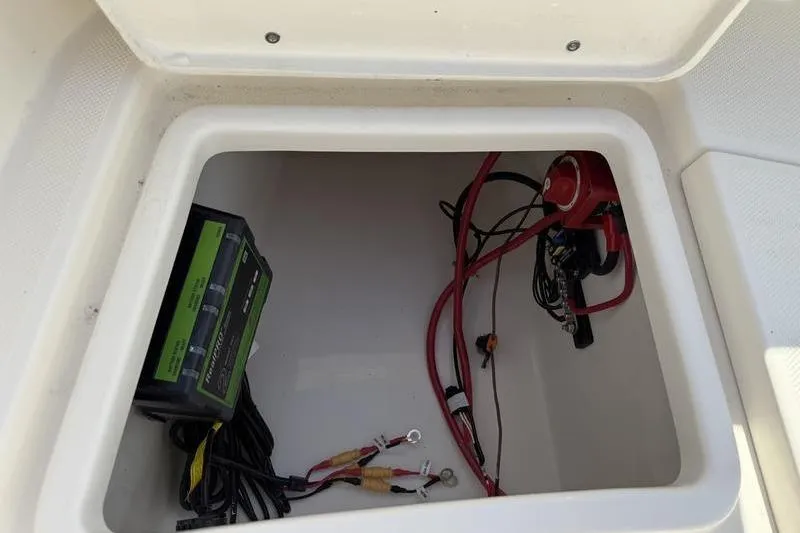 Slide: The Image of 2025 Bulls Bay 230 Center Console boat compartment with wiring and battery charger. - 21