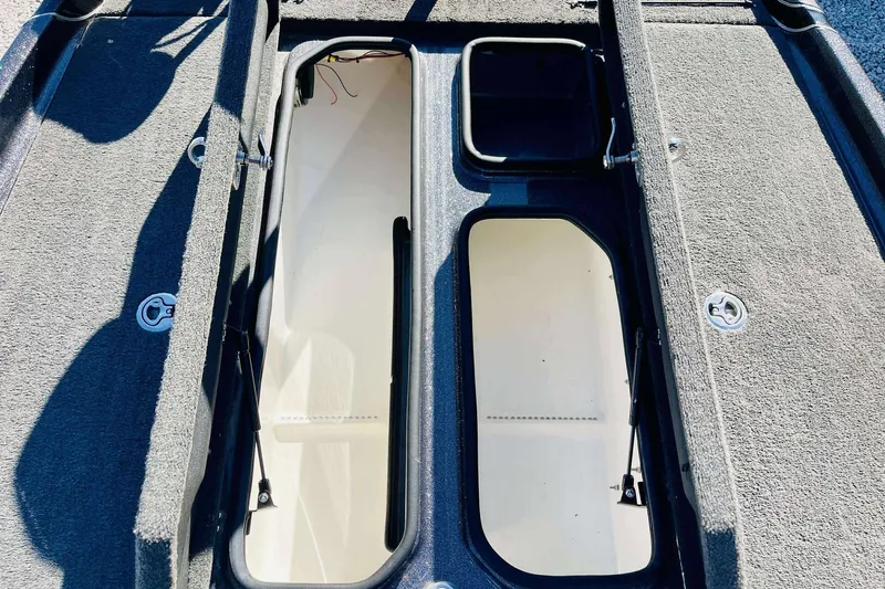 Slide: The Image of 2014 Bass Cat Eyra boat storage compartments with open lids, showcasing interior space. - 11