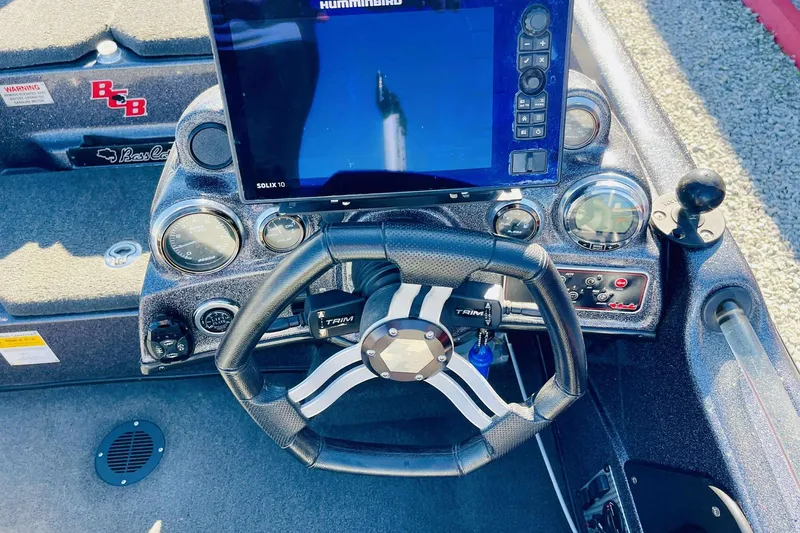 Slide: The Image of 2014 Bass Cat Eyra boat dashboard with steering wheel and Humminbird Solix 10 display. - 19